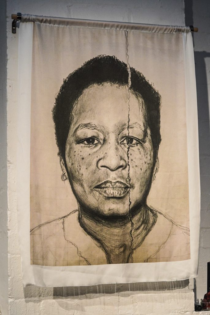 a pencil drawing of HCJ's grandmother printed on fabric and hung on a wall